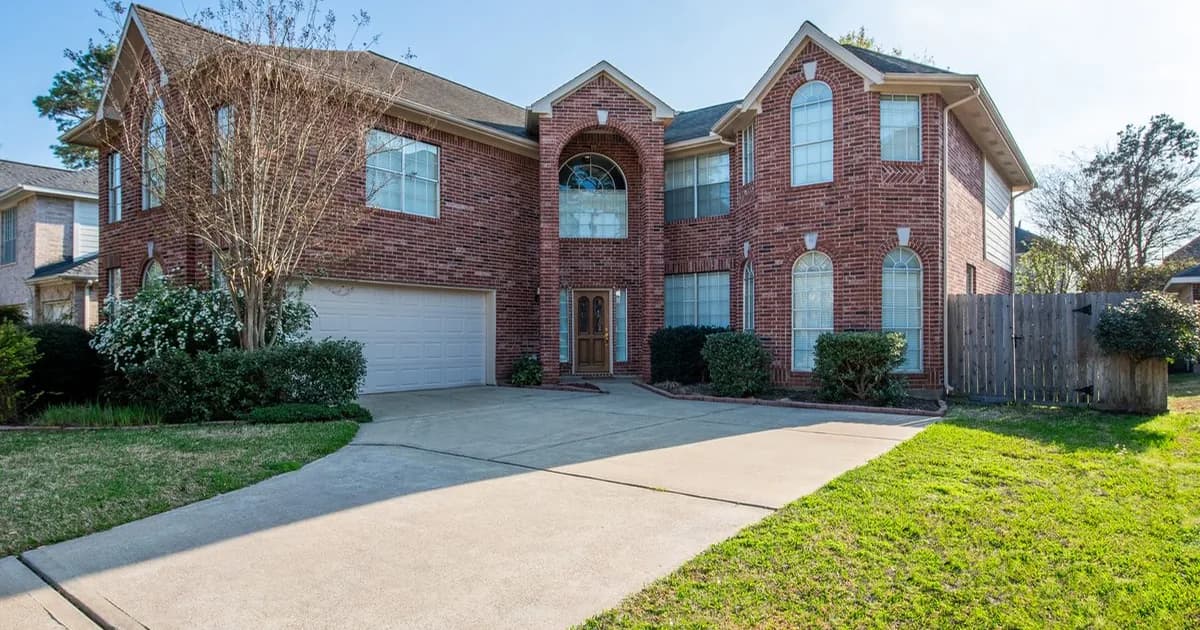 Established brick two-story Houston home with mature trees and paved driveway — Texas property tax protest landlord guide covering HCAD, MCAD, FBCAD, BCAD, and GalvCAD May 15 deadline