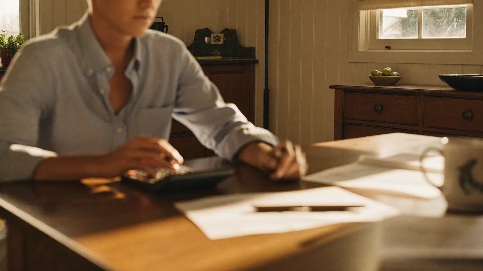 Maryland landlord reviewing a property management fee schedule at a dining table in a suburban home